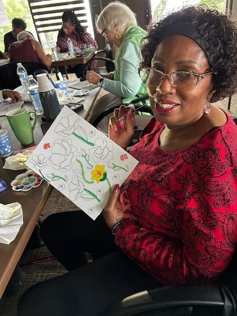 Lady with red top showing her painting