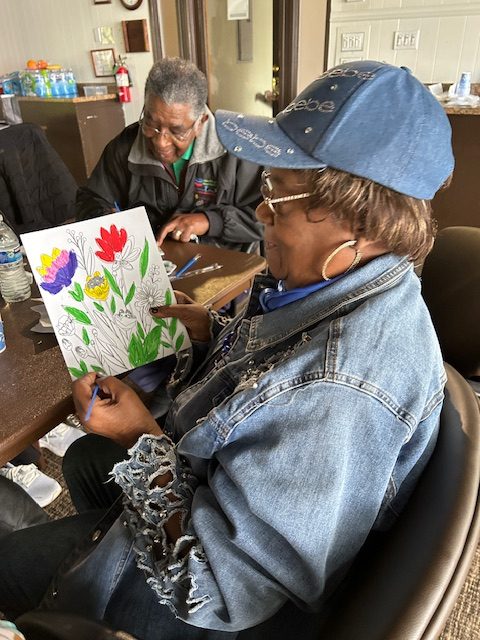 Woman wearing a baseball cap presents her painting