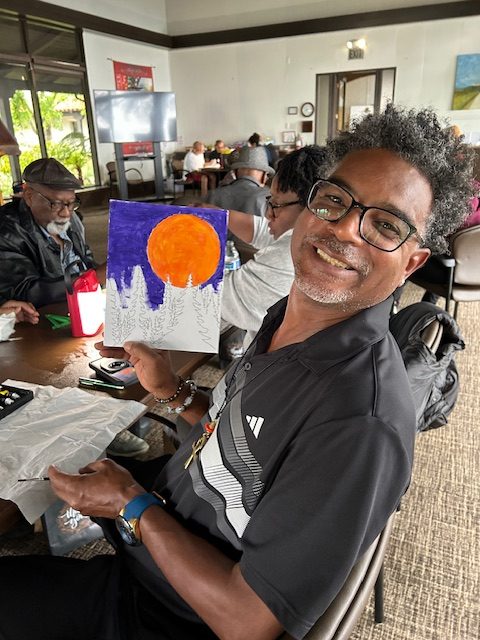 Man with a painting of a purple sky
